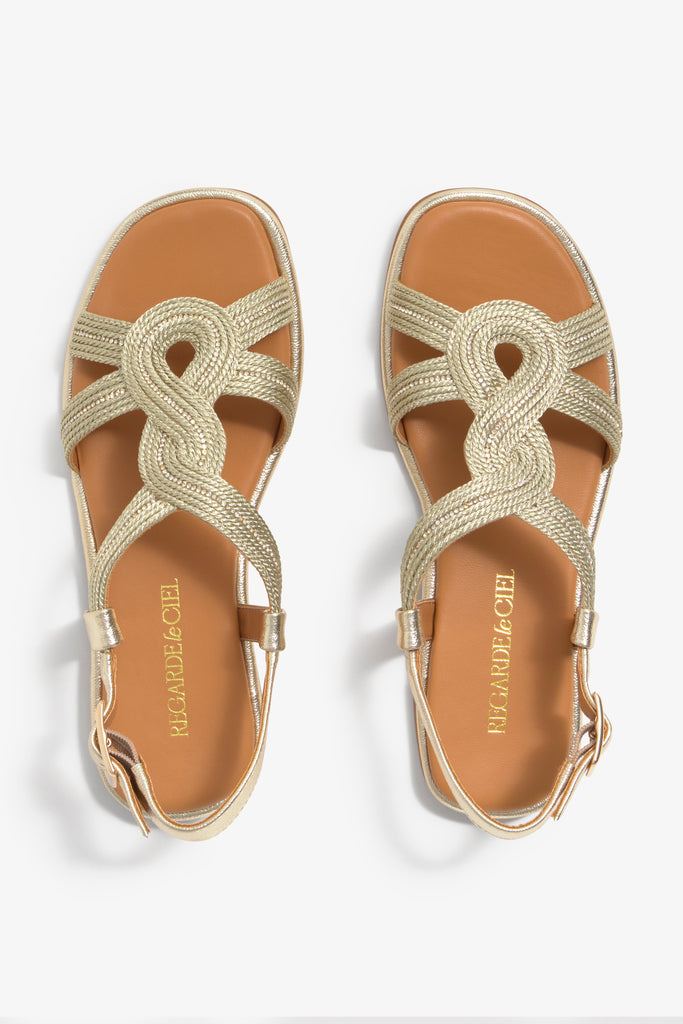 Women's flat gold strappy sandal with metallic woven details and ankle buckle strap.
