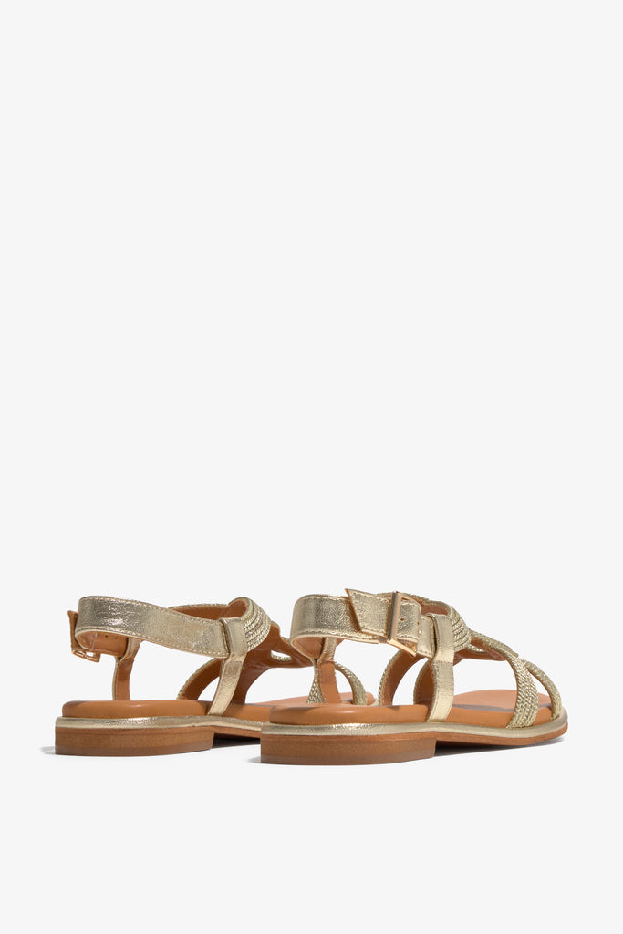 Women's flat gold strappy sandal with metallic woven details and ankle buckle strap.