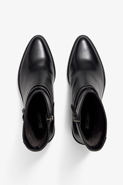 Black leather bootie with 60 mm block heel, two leather buckle straps, accentuated stitching and zipper, rubber sole.