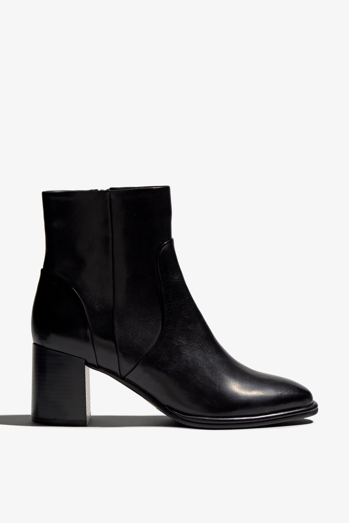 black leather ankle boot features a 65 mm heel, zipper, accentuated stitching, rubber sole, and plateau.