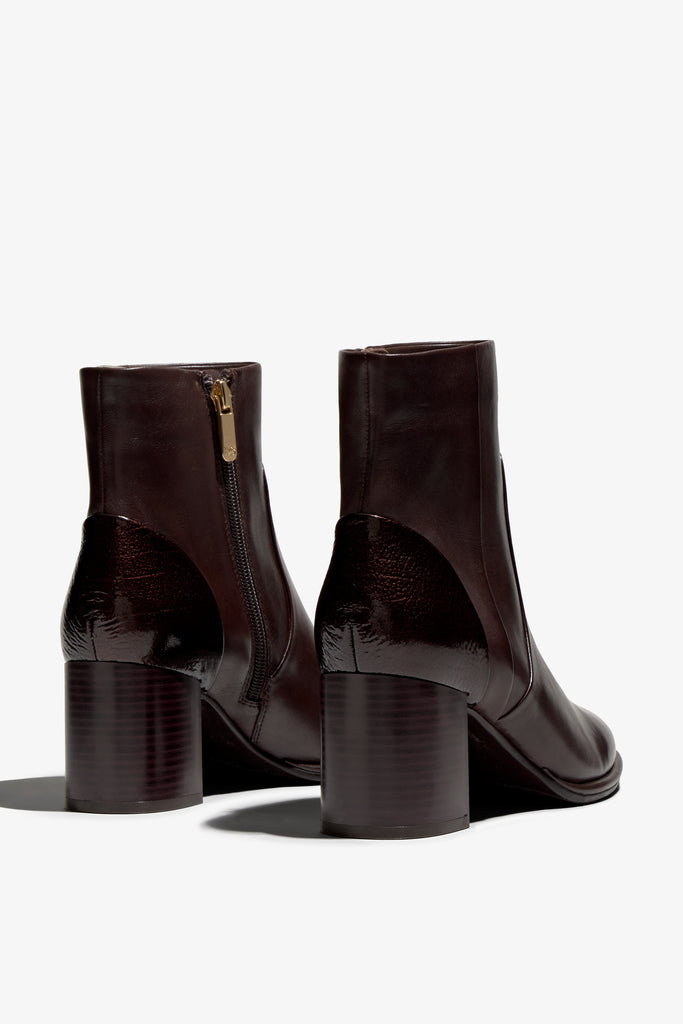castagno dark brown leather ankle boot features a 65 mm heel, zipper, accentuated stitching, rubber sole, and plateau.