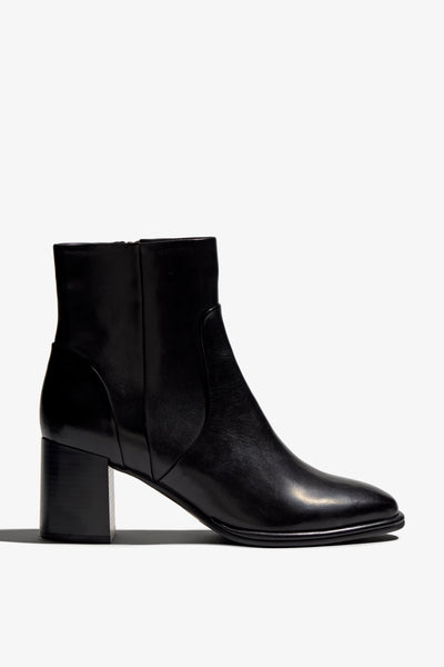 black leather ankle boot features a 65 mm heel, zipper, accentuated stitching, rubber sole, and plateau.