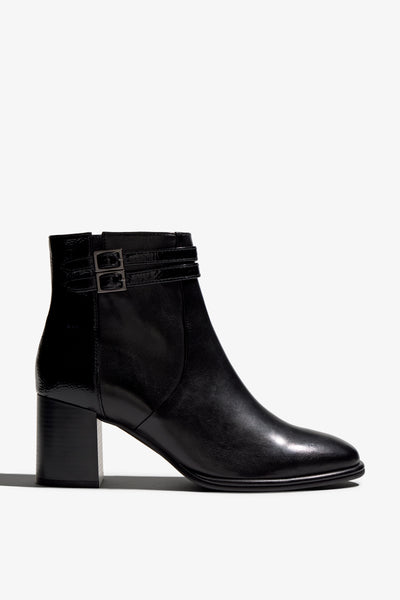 black leather ankle boot features a 65 mm heel, zipper, accentuated stitching, rubber sole, plateau and buckle straps.